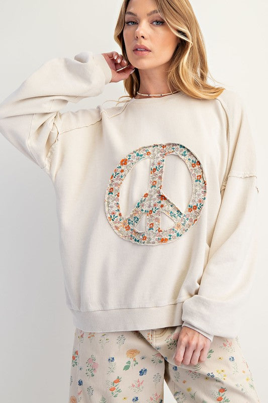 Oversized cotton sweatshirt with floral peace sign patch on the front. Available in sizes S-3X. Relaxed fit and boho-inspired style.