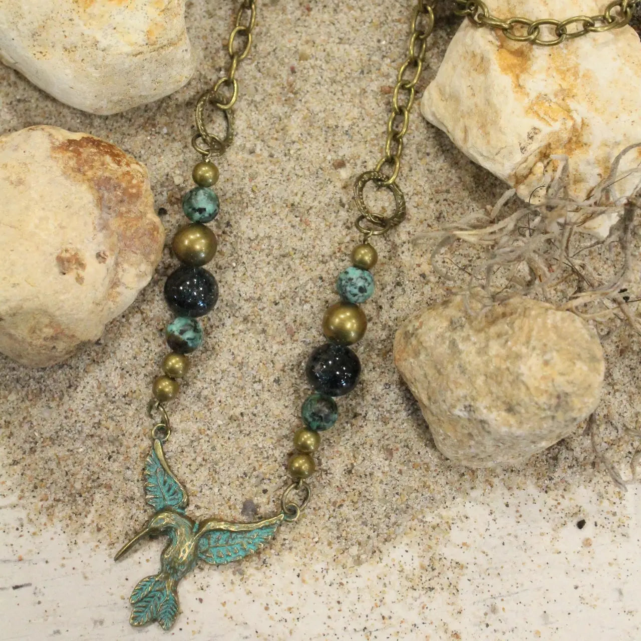 Boho hummingbird necklace with turquoise and bronze beads on 28-inch brass chain.