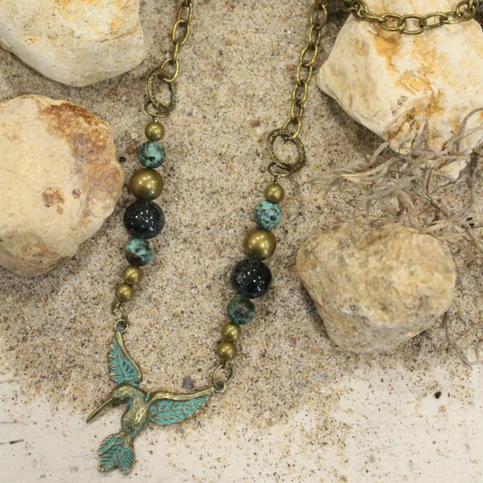 Boho hummingbird necklace with turquoise and bronze beads on 28-inch brass chain.

