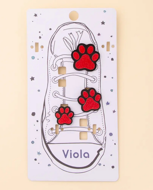 Set of three red glitter paw print shoe charms with black outline displayed on illustrated shoe card.