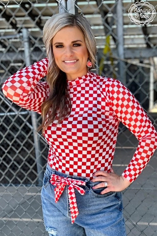 Woman wearing a red checkered sheer long sleeve top with mock neckline and jeans. Sizes S-3X.

