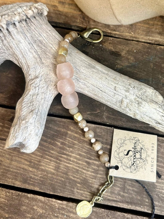 Bracelet with blush seaglass, cashmere agate beads, and matte gold accents on rustic wood background

