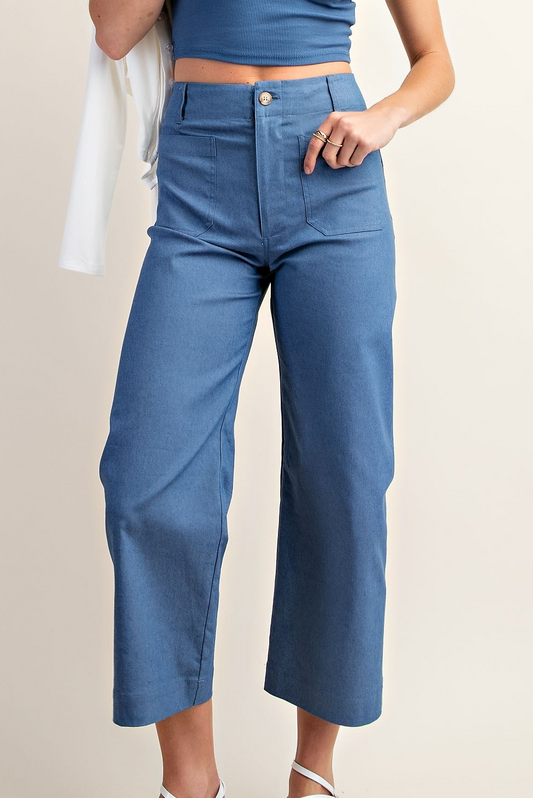 Woman wearing slate blue cropped high-rise pants with front pockets and wide-leg fit.