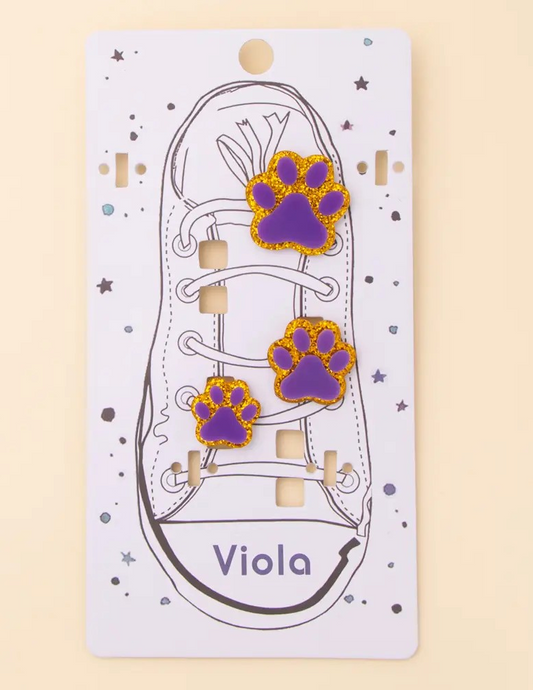 Set of three purple paw print shoe charms with gold glitter outline on illustrated shoe card.