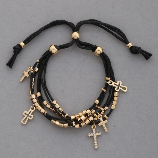 Layered black thread bracelet with gold beads and cross charms, including one rhinestone cross.
