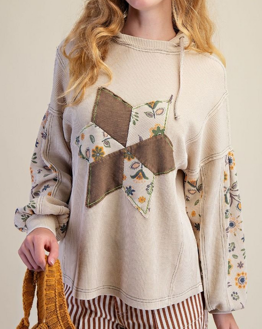 Beige thermal hoodie with floral patchwork sleeves and quilted star design on front.