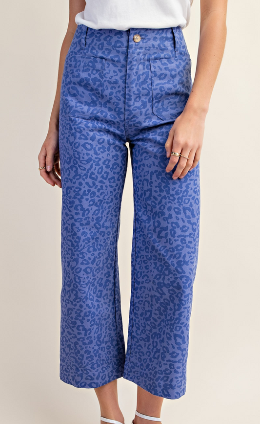 Close-up of high-rise indigo blue wide leg pants with tonal leopard print and front patch pockets.