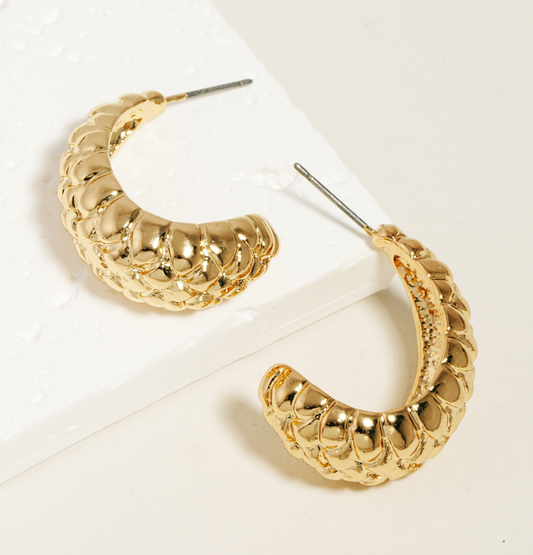 Small gold textured hoop earrings with quilted-style design on white background.