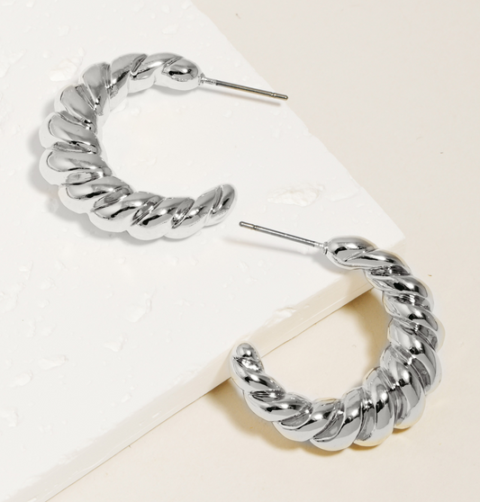 Silver hoop earrings with a thick twisted design on a white background.
